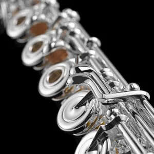 Close up of silver intermediate level flute lever keys for C# trill and open hole flute.